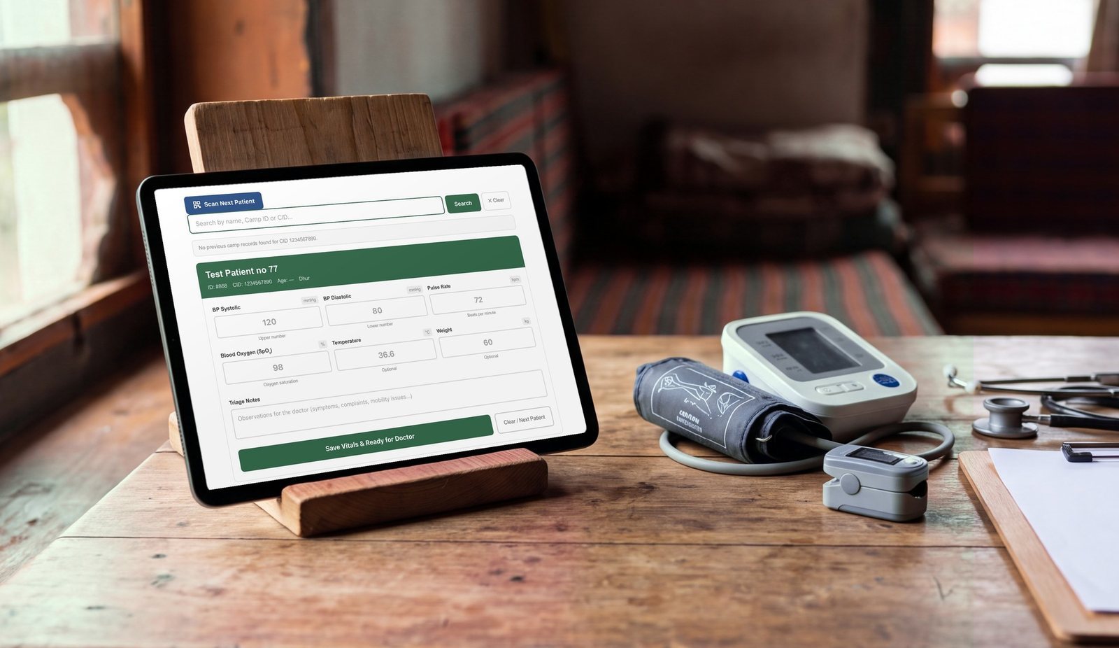 The Dhur Health Camp triage form on a tablet, beside a blood pressure monitor